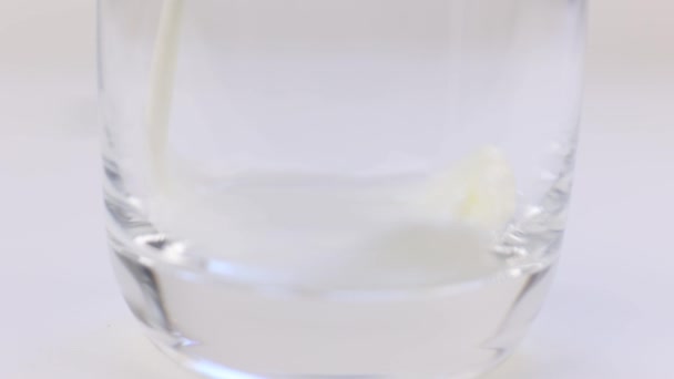 白い生乳を白い背景の透明なガラスに流し込み — ストック動画