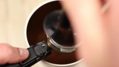  Taze öğütülmüş koyu kahve kaşıkla kahve makinesinin boynuzuna kaçar.