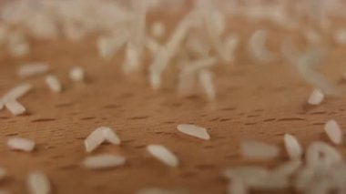 Masaya beyaz pirinç tanecikleri dökülüyor. Japon mutfağı için yavaş yavaş arka plan ekran koruyucusu.