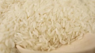Beyaz pirinç taneleri ahşap kaşık mutfak arka planındaki suşiden toplanır.