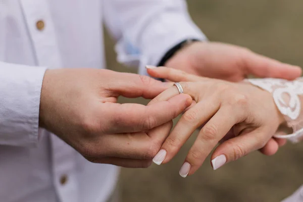 stock image groom puts a gold wedding ring on the bride's finger