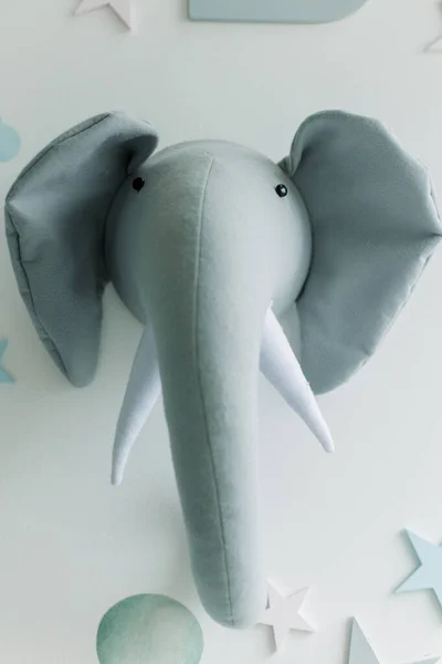 soft toy baby elephant hangs on the wall in the children's room