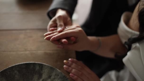 新郎在喜庆的餐桌前握住新娘的手 — 图库视频影像
