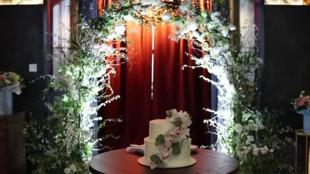 Μια Όμορφη Λευκή Γαμήλια Τούρτα Διακοσμημένη Λουλούδια Ένα Εστιατόριο — Αρχείο Βίντεο