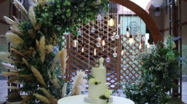 Akşam düğün kemerinin yanında güzel bir düğün pastası