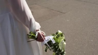 Gelin elinde bir düğün buketi tutuyor.