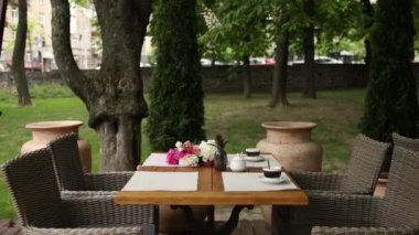 Parkta masaları ve kahveleri olan restoranın yaz terasında.