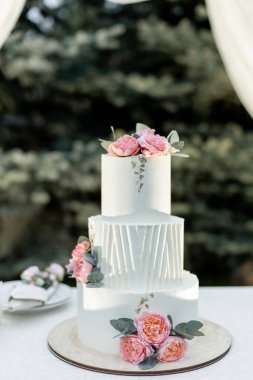 Akşam düğün kemerinin yanında güzel bir düğün pastası.