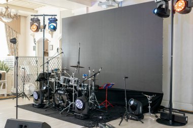 a Live music stage setup with drum set and professional lighting, ready for performance clipart