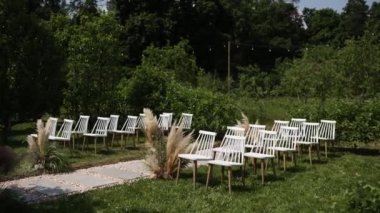 Sandalyeli bir parkta düğün töreni için güzel bir kemer.