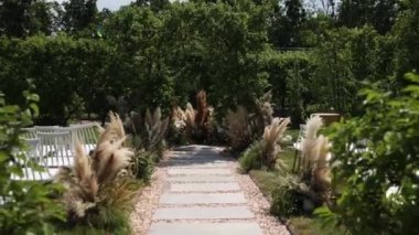 Sandalyeli bir parkta düğün töreni için güzel bir kemer.