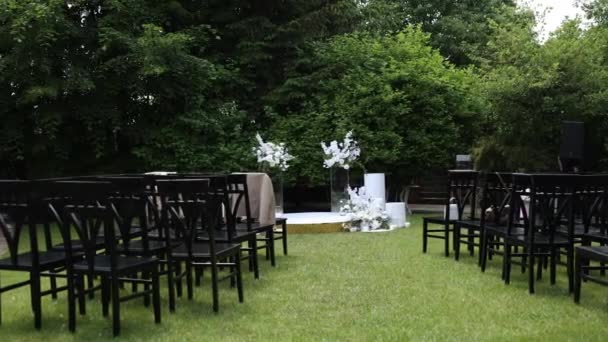 美しい花のアーチと静かな庭に設定された白い椅子と屋外の結婚式 — ストック動画