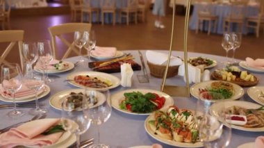 Çiçeklerle süslenmiş güzel bir düğün masası. Restoranda bir ziyafet için yiyecek ve içecekler.