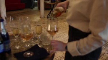 Garson barmen bardağa şarap doldurur.