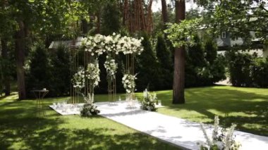 Sandalyeli bir parkta düğün töreni için güzel bir kemer.