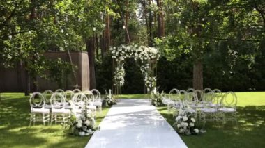 Sandalyeli bir parkta düğün töreni için güzel bir kemer.