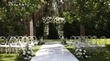 Sandalyeli bir parkta düğün töreni için güzel bir kemer.