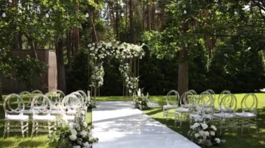 Sandalyeli bir parkta düğün töreni için güzel bir kemer.