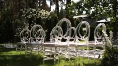 Sandalyeli bir parkta düğün töreni için güzel bir kemer.