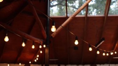 Restoran terasının ahşap tavanında ampuller.