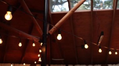Restoran terasının ahşap tavanında ampuller.