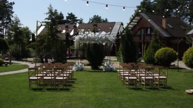 Sandalyeli bir parkta düğün töreni için güzel bir kemer.