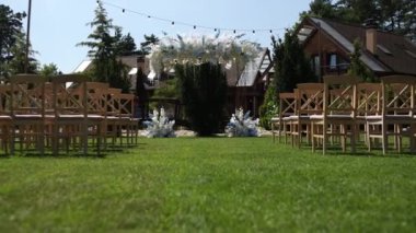 Sandalyeli bir parkta düğün töreni için güzel bir kemer.