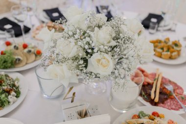 Düğün günü bir restoranda, şenlik masasında yiyecek ve içecekler.