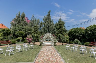 Sandalyeli bir parkta düğün töreni için güzel kemer.