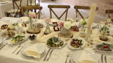 Düğün ya da doğum gününde çiçeklerle süslenmiş bir restoranda bir masa.