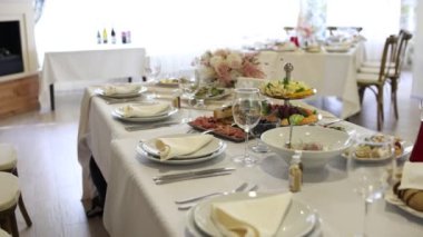 Düğün ya da doğum gününde çiçeklerle süslenmiş bir restoranda bir masa.