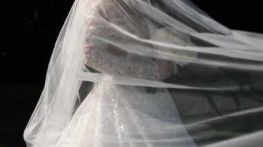  Düğündeki gelin beyaz elbiseli ve bir buket çiçekli.
