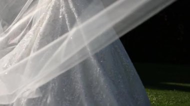  Düğündeki gelin beyaz elbiseli ve bir buket çiçekli.