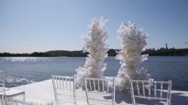 Nehir kıyısında sandalyeleri olan bir düğün kemeri.