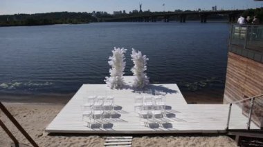 Nehir kıyısında sandalyeleri olan bir düğün kemeri.