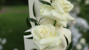 Tören için kemerin yanında güzel beyaz düğün pastası.