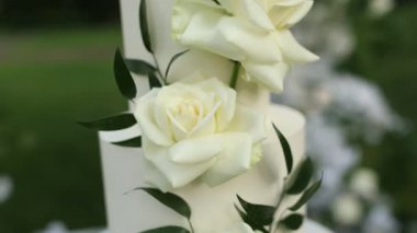 Tören için kemerin yanında güzel beyaz düğün pastası.