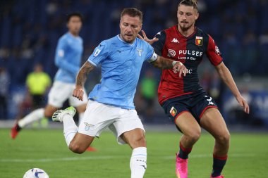 Roma, İtalya 27.08.2023: Lazio 'lu Ciro Immobile, Cenova' lı Radu Dragusin İtalya Serisi A TIM 2023-2024 futbol maçının 2. gününde Roma 'daki Olimpiyat Stadyumu' nda SS Lazio 'ya karşı Cenova CFC arasında hareket halindedir..