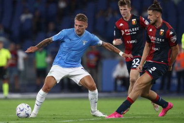 Roma, İtalya 27.08.2023: Lazio 'lu Ciro Immobile, Cenova' lı Radu Dragusin İtalya Serisi A TIM 2023-2024 futbol maçının 2. gününde Roma 'daki Olimpiyat Stadyumu' nda SS Lazio 'ya karşı Cenova CFC arasında hareket halindedir..