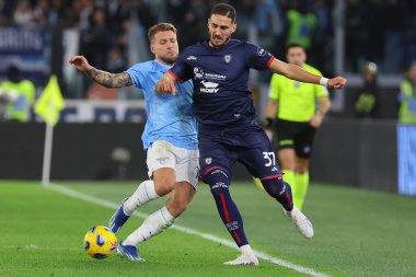 Roma, İtalya 02.12.2023: Lazio 'lu Ciro Immobile İtalya Serie A TIM 2023-2024 futbol karşılaşmasında Cagliari' li Paulo Azzi ile top için Roma 'daki Olimpiyat Stadyumu' nda SS Lazio ile Cagliari Calcio arasında mücadele etti..