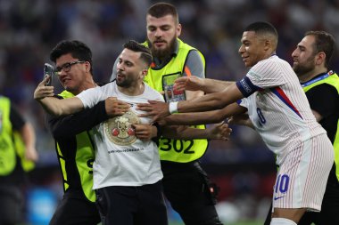 Münih, Almanya 09.07.2024: taraftar UEFA 2024 yarı finalleri sırasında Fransa 'nın Kylian Mbappe ile fotoğraf çekmek için sahaya akın etti.
