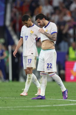 Münih, Almanya 09.07.2024: Fransız oyuncular Fransız Theo Hernandez, UEFA 2024 yarı finalinde Fransa ile Fransa arasında oynanan Münih Futbol Federasyonu Allianz Arena maçında oynanan yenilgi sonrasında Fransız William Sthe hayal kırıklığına uğradı.