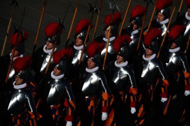 Vatikan Şehri, İtalya 25.12.2024: Tam üniformalı İsviçreli Muhafızlar, Noel için Papa Francis 'in Urbi et Orbi kutsaması vesilesiyle Aziz Peter Meydanı' nın merkezi logosu altında yer almak üzere meydana yürüyorlar..