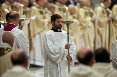 Vatikan Şehri, İtalya 24.12.2024: Aziz Petrus Bazilikası Vatikan Şehri 'nde binlerce inananın önünde Noel ayini sırasında ellerinde mumlar olan rahipler