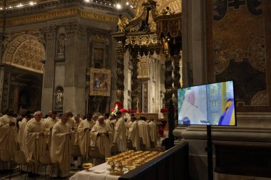 Vatikan Şehri, İtalya 24.12.2024: Papaz Francis, Aziz Peter Bazilikası 'ndaki Kutsal Kapı' yı 2025 yılının yıldönümü için açarken, binlerce inançlı Aziz Peter Bazilikası Vatikan Şehri Roma 'sında Noel Ayini' ni kutladıktan sonra, papazlar televizyon izler.