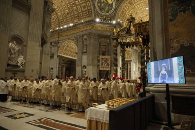 Vatican City, Italy 24.12.2024 : Priests watch tv  while Pope Francis opens the Holy Door in St. Peter's Basilica for the Jubilee 2025, after celebrates Christmas Mass in front of thousands of faithful, in St. Peter's Basilica Vatican City Rome clipart