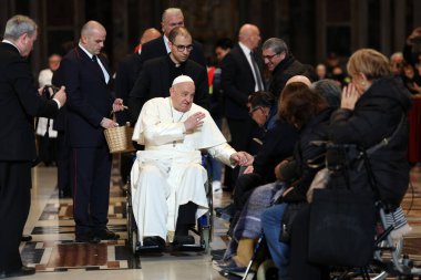 Roma, İtalya 06.01.2025: Papa Francis Bergoglio tekerlekli sandalyeyle uzaklaşıyor ve çocukları selamlıyor, Kutsal Ayin 'in günah çıkarma sunağı Aziz Peters Bazilikası' nda yapılan ayinden sonra sadık kalamıyor.