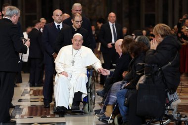 Roma, İtalya 06.01.2025: Papa Francis Bergoglio tekerlekli sandalyeyle uzaklaşıyor ve çocukları selamlıyor, Kutsal Ayin 'in günah çıkarma sunağı Aziz Peters Bazilikası' nda yapılan ayinden sonra sadık kalamıyor.