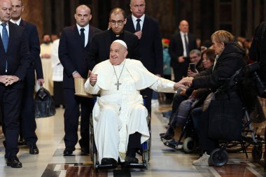 Roma, İtalya 06.01.2025: Papa Francis Bergoglio tekerlekli sandalyeyle uzaklaşıyor ve çocukları selamlıyor, Kutsal Ayin 'in günah çıkarma sunağı Aziz Peters Bazilikası' nda yapılan ayinden sonra sadık kalamıyor.