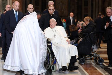 Roma, İtalya 06.01.2025: Papa Francis Bergoglio tekerlekli sandalyeyle uzaklaşıyor ve çocukları selamlıyor, Kutsal Ayin 'in günah çıkarma sunağı Aziz Peters Bazilikası' nda yapılan ayinden sonra sadık kalamıyor.